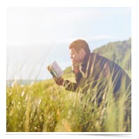 Man reading by a lake.