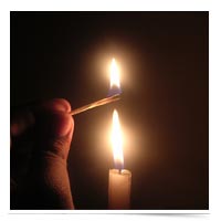 Hand lighting a candle.