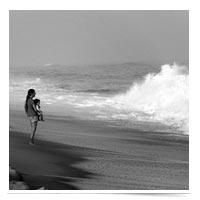 Image of woman with child facing waves.