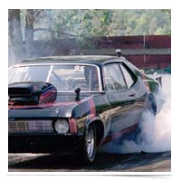 Image of a drag racing car burning rubber, going nowhere.