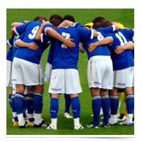 Image of soccer players huddled up.
