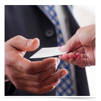 Image of man taking business card from a woman.