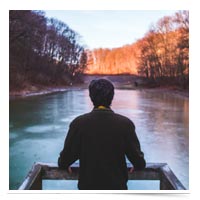 Man reflecting on a river.