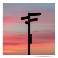 Directional road signs at sundown.